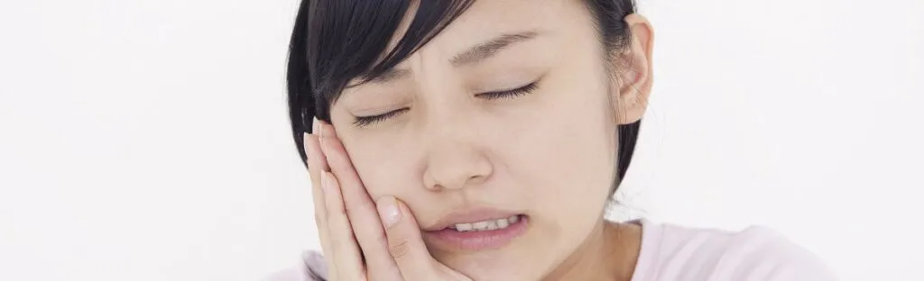 顎を抑えている女性