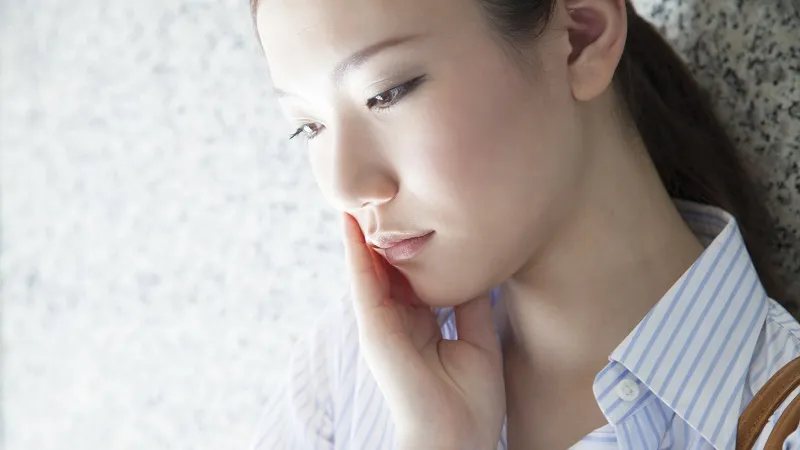 口元を抑えている女性